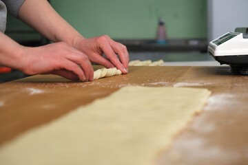 the process of making Grissini. grissini with olives and thyme recipe. cook cuts grissini. baker at work. The baker shapes the bread. Hands on the close-up foruyut bread