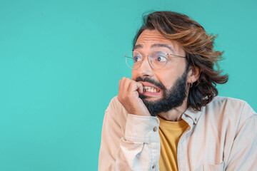 Phobia and anxiety disorder. Young nervous frightened man biting nails over isolated background