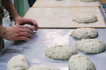 baker at work. The baker shapes the bread. Hands on the close-up form bread
