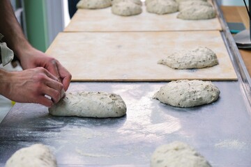 baker at work. The baker shapes the bread. Hands on the close-up form bread