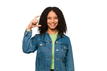 Young african american curly woman isolated holding something little with forefingers, smiling and confident.