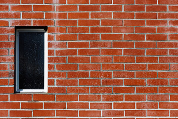 Fototapeta premium red brick wall with small vertical window.