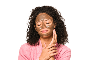 Young african american curly woman wearing a bathrobe and a facial mask isolated