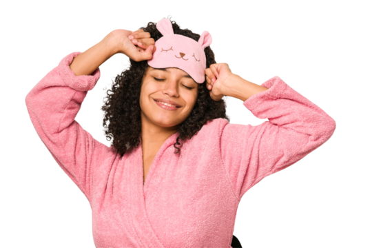 Young african american curly woman wearing a sleep mask isolated