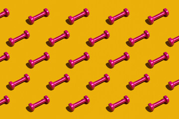 Bright pink dumbbells on a yellow background