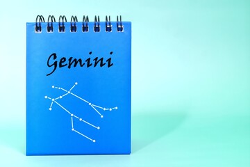 Gemini zodiac sign on blue desk calendar notepad. Horoscope and astrology concept.