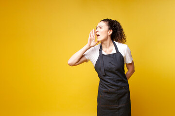 young girl waiter in uniform speaks to the side and announces information on a yellow background
