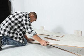 Professional worker installing new laminate flooring indoors