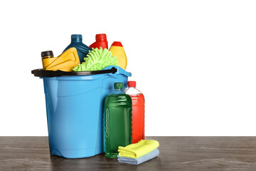 Light blue bucket and many different car wash products on black wooden table against white background © New Africa