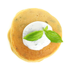Stack of tasty corn pancakes with sauce and basil leaves isolated on white, top view