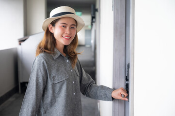 Happiness Asian tourist woman standing in front of hotel room.