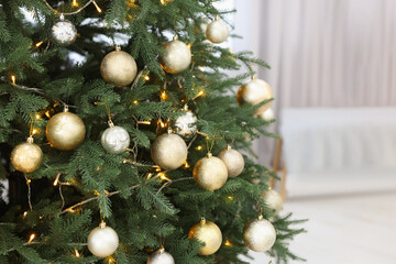 Beautiful Christmas tree with festive lights and colorful balls indoors