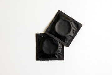 Fototapeta premium black condom on white background, top view, safe sex concept