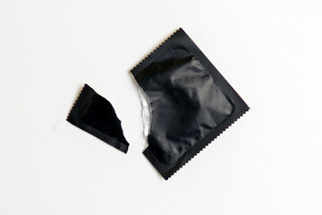 torn pack of condom on white background, safe sex concept