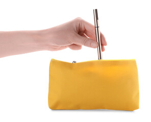 Woman taking out eyeliner from yellow cosmetic bag on white background, closeup