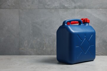 New blue plastic canister on floor near light grey wall, space for text