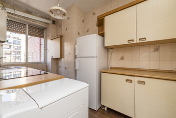 Antique apartment kitchen with light-colored cabinets with matching wood countertops and white appliances
