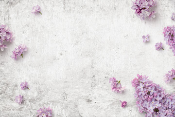 romantic floral composition with loosely arranged lilac flowers on a rustic white wooden...