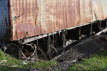 Fototapeta na wymiar rotted foundation under old barn