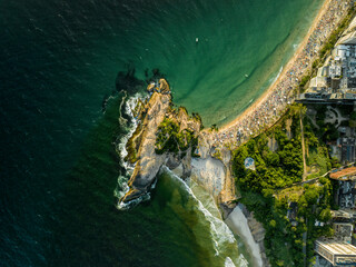 People watching sunset on small Arpoador peninsula between Ipanema and Copacabana Beach, Rio de Janeiro, Brazil. aerial high angle view
