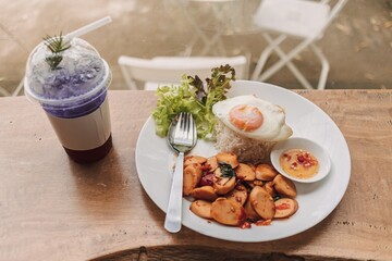 Thai Rice topped with stir-fried sausages and basil with fried egg.