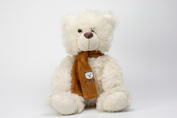 Cute white Teddy bear with a brown scarf on a white background. Plush toys for kids.