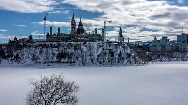 4k timelapse from Majors Hill Park in downtown Ottawa Canada with view to the historical buildings of the Canadian parliament and its surroundings at a cold but sunny day in winter.