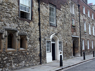 Ancient worn down stone facade around the entrance to Westminster School in London, dating from the middle ages, adjacent to Westminster Abbey