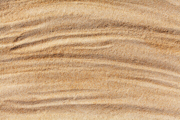 Wavy yellow sand texture closeup background, sandy waves pattern, natural beige sand grains backdrop, rippled dry sand surface top view, light orange desert dune, summer tropical sea beach, copy space