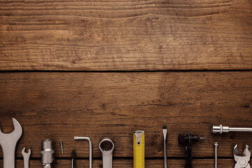 Flat lay with various work tools on wooden background working table. Top view on new hand tool set...