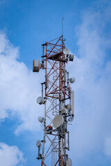 Telecommunication tower with blue and white clouds sky. Copy space.