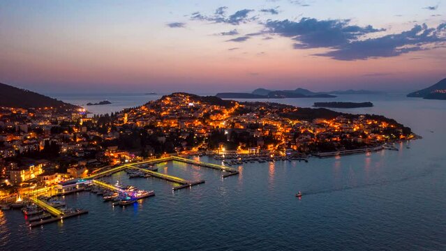 Aerial hyperlapse of Dubrovnik, Croatia lit up by city lights on a warm summer evening.