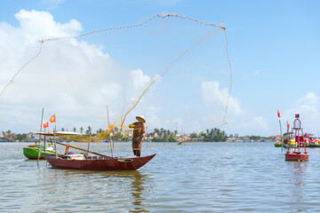 Fisherman Fishing Net on the boat at Cam thanh village. Landmark and popular for tourists...