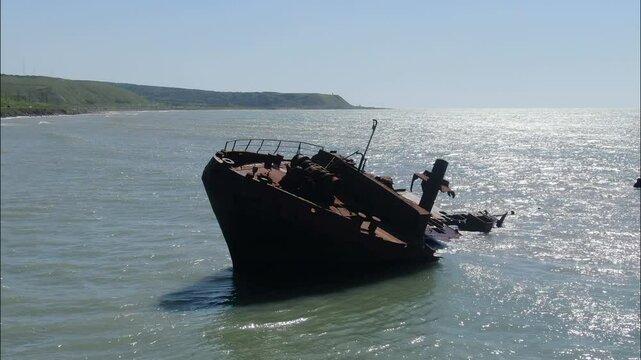 A rusty ship is at sea after the crash. the coast of Sakhalin Island. the city of Nevelsk