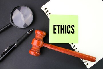 judge's gavel, pen, magnifying glass and paper with the word ethics. the concept of ethics or...