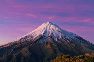 Fototapeta premium Mount Taranaki at sunrise with purple sky and clouds