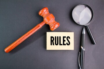 magnifying glass, pen and judge's gavel with the word RULES. the concept of rules or orders is set