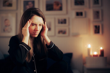 Stressed Woman Suffering a Migraine at Night before Going to Sleep. Unhappy adult person having headaches from insomnia
 - obrazy, fototapety, plakaty