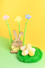 Wooden bunny, yarn flowers, round decorative grass carpet with textured Easter eggs on yellow-green.