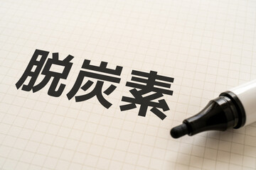脱炭素と書かれたノートとマーカー
