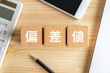偏差値と書かれたブロック、電卓、スマホ、ノート