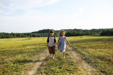 Naklejka premium Children walk in the summer in nature. Child on a sunny spring morning in the park. Traveling with children.