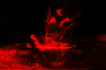 Red smoke over black studio background. Red steam on a black background. Copy space.