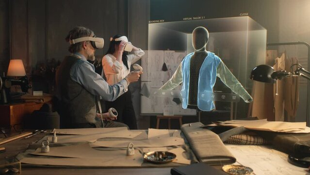 Tailor and female designer in VR headsets work with 3D hologram of clothes in atelier. Virtual interface menu of software for designing and modeling garment. Digital technology and augmented reality.