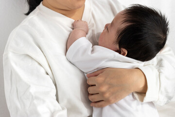 母親に抱っこされて寝る赤ちゃん（0歳2か月、日本人、男の子）