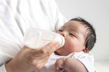 母親に抱っこされて寝ながらミルク飲む赤ちゃん（0歳2か月、日本人、男の子） - obrazy, fototapety, plakaty