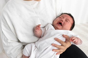母親に抱っこされて泣く赤ちゃん（0歳2か月、日本人、男の子）