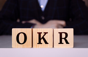 The word "OKR" written on wood cube. OKR - short for Objectives and Key Results