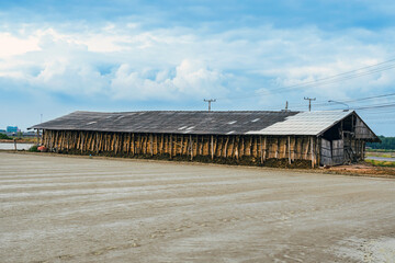 Salt storage granaries, sea salt storage in salt farms. Granary for salt storage and salt farm Solar. Abandoned old wood salt barn storage. Traditional wooden barn for storing salt beside salt pan.