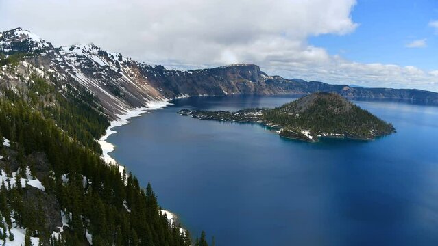 Crater Lake - A time-lapse overview of blue Crater Lake and rocky Wizard Island on a cloudy Spring morning. Crater Lake National Park, Oregon, USA.